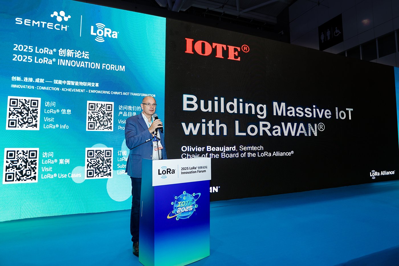 Olivier Beaujard, Senior Director of the LoRa Ecosystem at Semtech and Chair of the LoRa Alliance Board, presenting 'Building Massive IoT with LoRaWAN' at the 2025 LoRa Innovation Forum with IOTE branding visible on stage backdrop