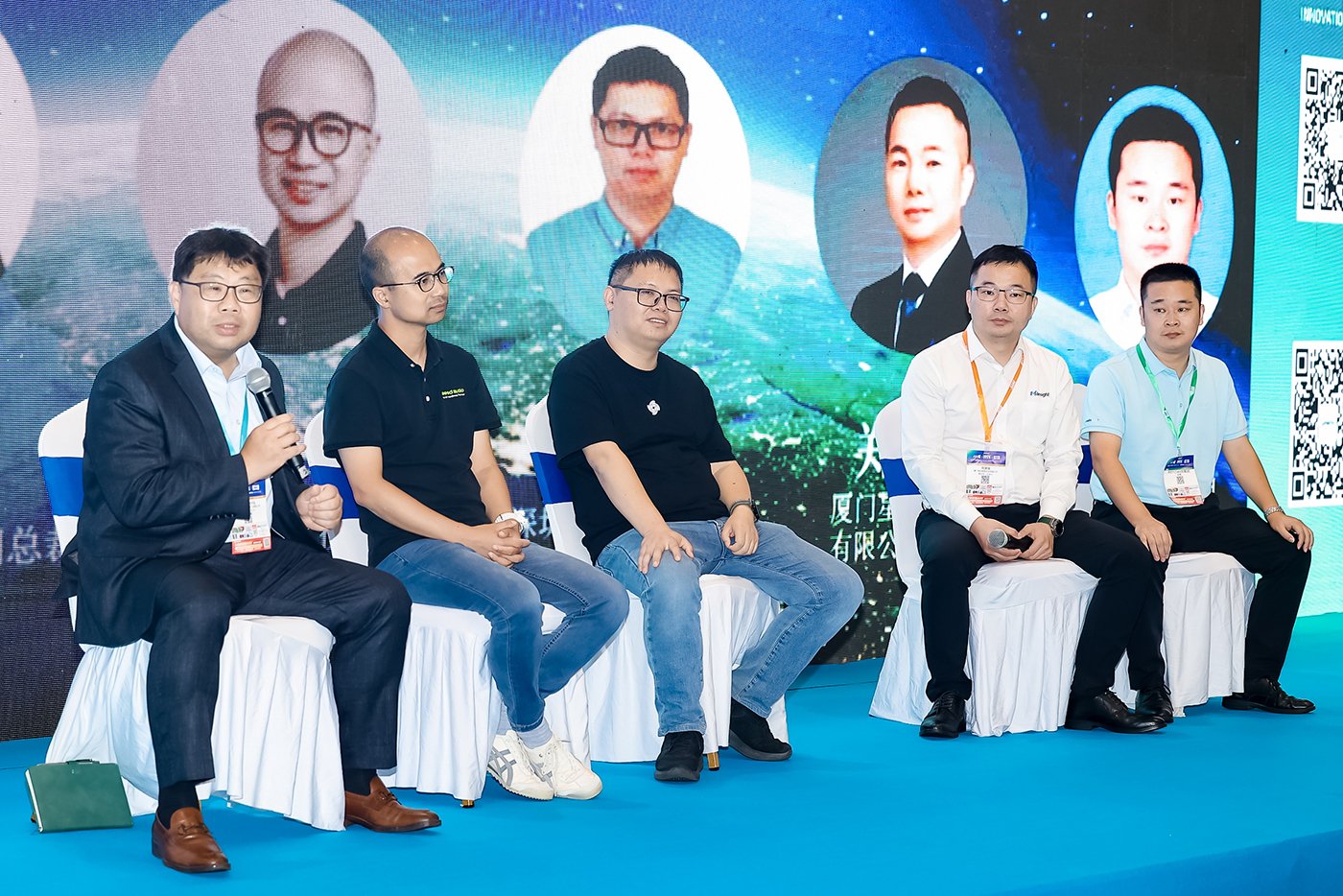 Strategic market insights panel discussion featuring Mike Wong as moderator with four industry panelists seated on stage, with portraits of additional participants displayed on the backdrop screen for the Global Expansion Panel & Conclusions session