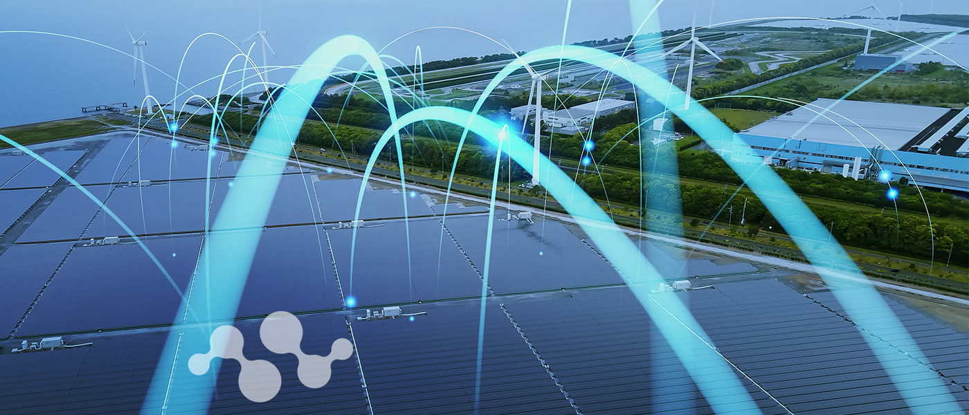 Aerial view of a large solar panel farm with wind turbines in the background, overlaid with glowing blue digital network connections and data nodes representing LoRa/LoRaWAN IoT connectivity and smart monitoring technology for renewable energy infrastructure.