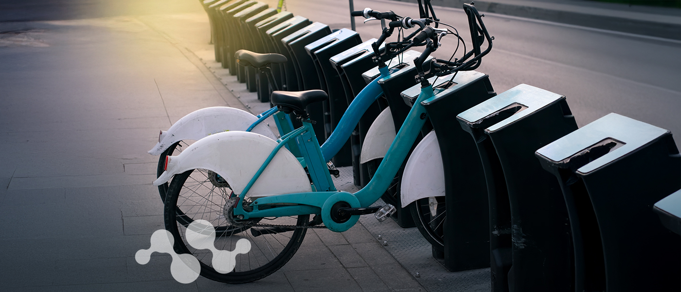 E-bikes at urban bike-sharing docking station, showcasing micromobility revolution in city transportation
